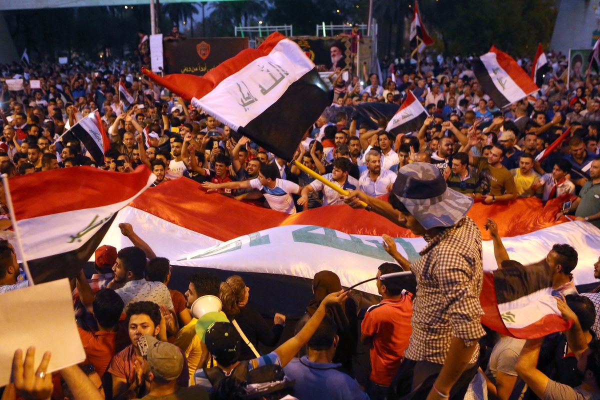 Demonstrators chant in support of Iraqi Prime Minister Haider al-Abadi as they wave national flags during a demonstration in Baghdad, Iraq, Sunday. (Associated Press)