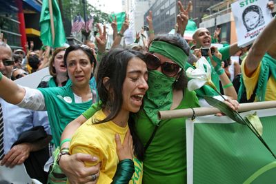 Saarar Azadi  is comforted by a fellow demonstrator  during a rally in New York against the Iranian government.  (Associated Press / The Spokesman-Review)