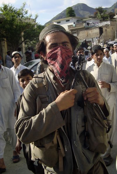A Pakistani Taliban member holds his weapon as he leaves Buner, in northwestern Pakistan, on Friday.  (Associated Press / The Spokesman-Review)