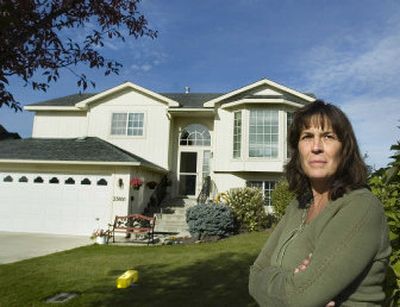 
Peggy Armstrong, standing in front of her Liberty Lake house on Tuesday,  and her husband, Ken, are house-hunting to get away from MeadowWood's rules. They were notified they'd be fined if they didn't remove their newspaper box, which they were told violated the neighborhood's architectural rules. 
 (Joe Barrentine / The Spokesman-Review)