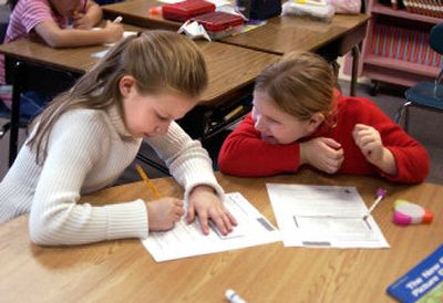 
Left to right, third-graders Alina Lashay, 9, and Svetlana Babakova, 8, complete a worksheet on the 