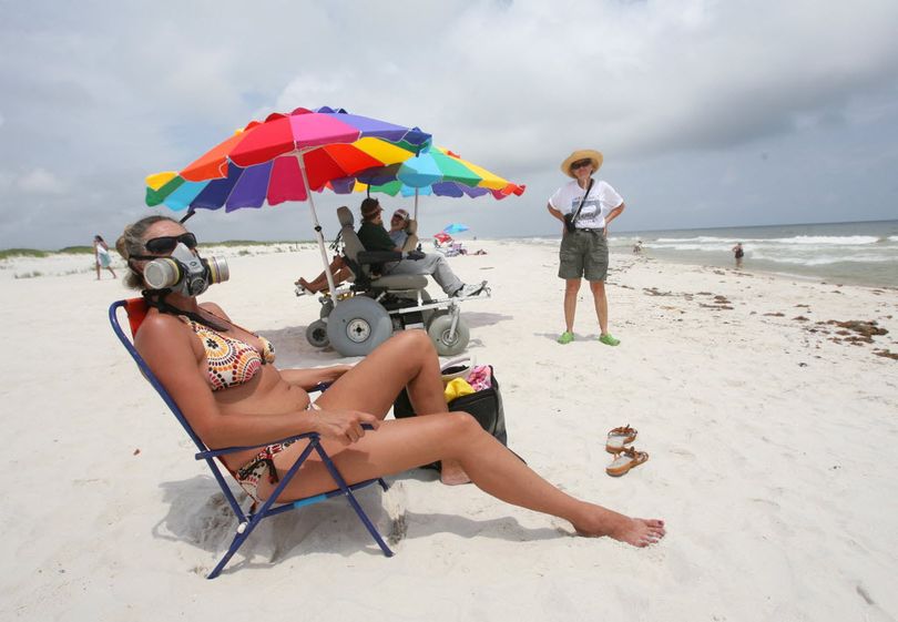 Sonja Daniel, who has a house on the Fort Morgan Peninsula, wears a mask Sunday, June 6, 2010 as she sunbathes on the beach of the Bon Secour National Wildlife Refuge in Baldwin County, Ala. Cleanup crews were working Sunday to remove tar balls and oily patches from the shoreline as managers at the refuge readied plans to construct dunes and berms to protect sensitive lagoons and wetlands. (Kate Mercer / Mobile Press Register)