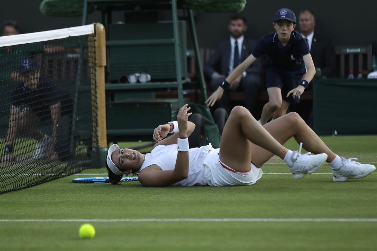 Spain’s Garbine Muguruza falls trying to return the ball to Alison Van Uytvanck of Belgium, during their women’s singles match, on the fourth day at the Wimbledon Tennis Championships in London, Thursday July 5, 2018. (Ben Curtis / Associated Press)
