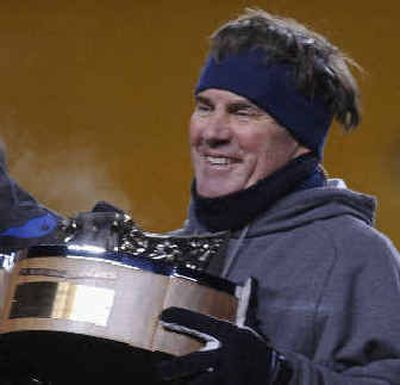 
Patriots coach Bill Belichick cracks a rare smile as he holds the AFC Championship trophy Sunday.
 (Associated Press / The Spokesman-Review)