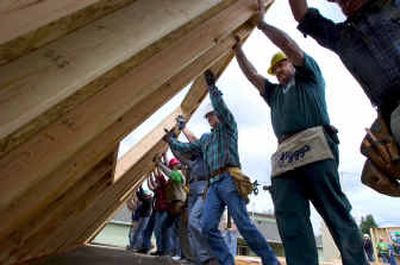 
As part of Blitz Build 2005, volunteers raise the exterior wall of a new duplex being built by Habitat for Humanity on the 1700 block of East Boone Avenue on Wednesday. 
 (Colin Mulvany / The Spokesman-Review)