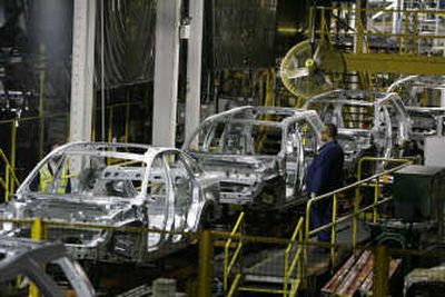 
A Ford Motor Co. employee watches chassis for the 2008 models roll by on the assembly line at the Chicago Assembly Plant. Ford announced its first quarterly profit in two years.
 (Associated Press / The Spokesman-Review)