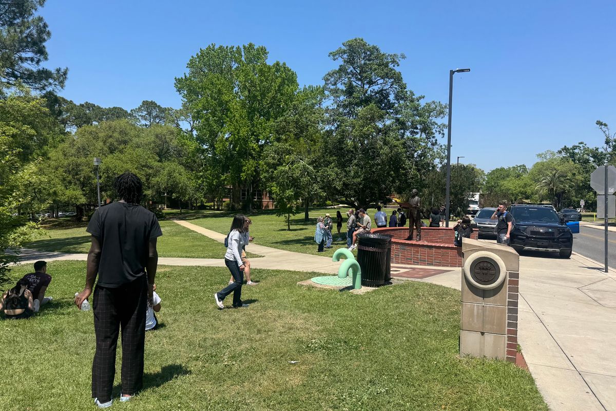 Florida State University students and faculty members wait in a grassy area near the student union where the active shooting was reported.  (Ana Ceballos)