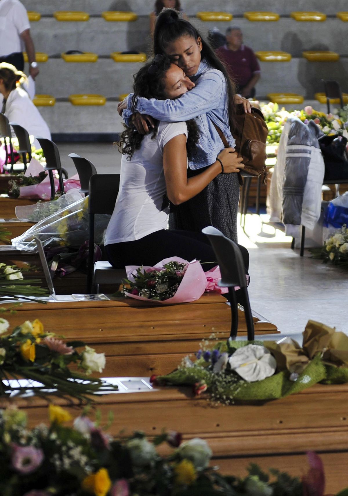 Two girls embrace each other in Ascoli Piceno, central Italy, Saturday, Aug. 27, 2016, as they wait for the start of a mass funeral for some of the victims of the earthquake that devastated central Italy on Wednesday. (Cristiano Chiodi / Associated Press)