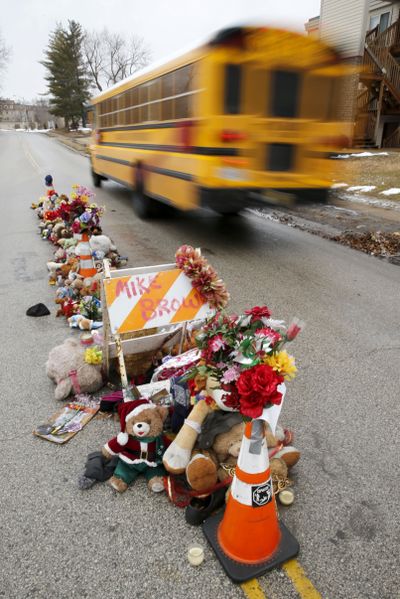 A school bus on Tuesday passes the scene where Michael Brown was fatally shot by a Ferguson, Missouri, police officer. (Associated Press)