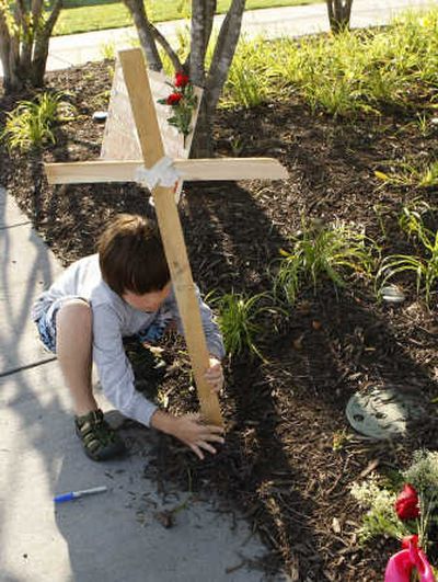 
Quinn Martin, 9, places a cross Tuesday at the Gold Medal Park in Minneapolis  as part of a memorial  for  Interstate 35W bridge collapse victims. Associated Press
 (Associated Press / The Spokesman-Review)