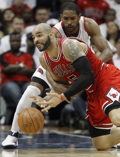 Hawks’ Al Horford, back, battles Bulls’ Carlos Boozer for loose ball during Chicago’s series-clinching 93-73 victory. (Associated Press)