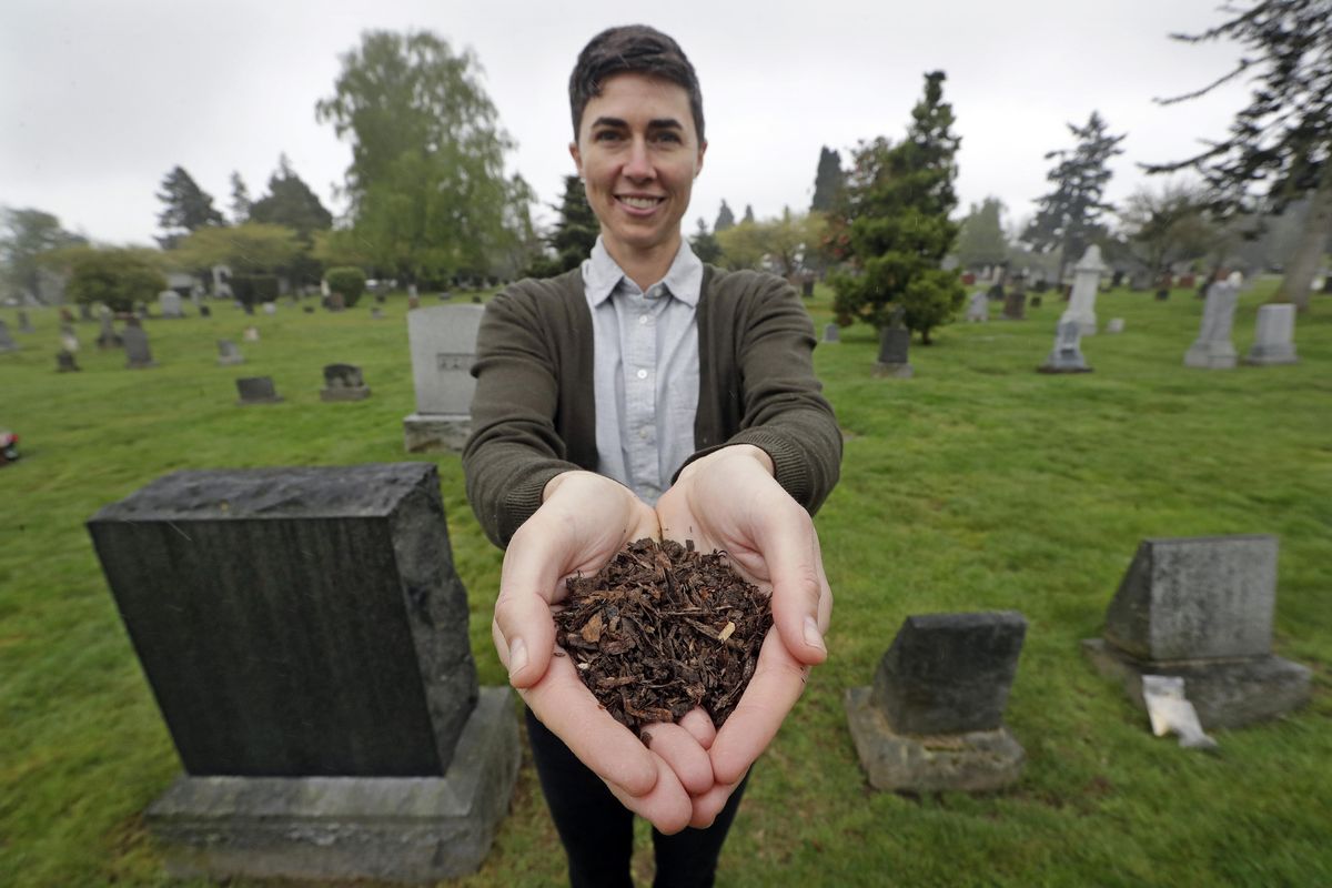 Katrina Spade, the founder and CEO of Recompose, a company that hopes to use composting as an alternative to burying or cremating human remains, on April 19, 2019, in a cemetery in Seattle, as she displays a sample of compost material left from the decomposition of a cow using a combination of wood chips, alfalfa and straw. On Tuesday, May 21, 2019, Washington Gov. Jay Inslee signed a bill into law that allows licensed facilities to offer “natural organic reduction,” which turns a body, mixed with substances such as wood chips and straw, into soil in a span of several weeks. Th law makes Washington the first state in the U.S. to approve composting as an alternative to burying or cremating human remains. (Elaine Thompson / AP)