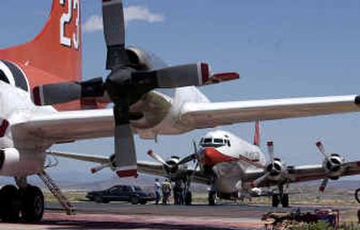 A 1964 P-3 Orion air tanker, foreground, and a 1947 DC-6 tanker sit grounded on the tarmac outside of the Prescott Fire Center at the airport in Prescott, Ariz., in May. At least seven P-3 Orion aircraft are expected to be back in firefighting service soon.
(Associated Press / The Spokesman-Review)