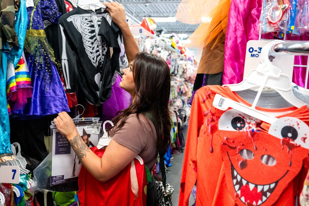 Megan Marotta, of Pitman, shops for Halloween costumes for her two young daughters at Once Upon a Child in Deptford, N.J., on Sept. 22. The South Jersey store sells Halloween costumes for $8.86 on average.  (Tom Gralish/Philadelphia Inquirer)