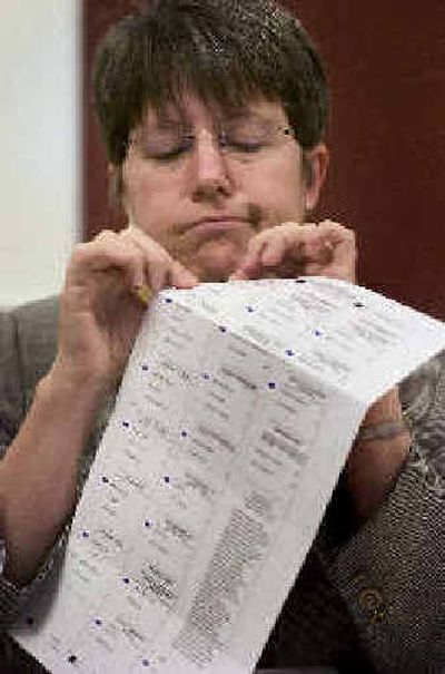 Spokane County Auditor Vicky Dalton looks closely at a ballot to try to determine the voter's intent Friday. The ballot ultimately was not counted.
(Colin Mulvany / The Spokesman-Review)
