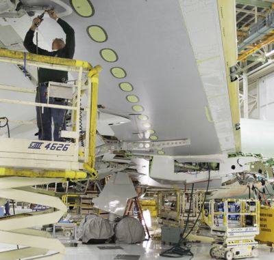 A Boeing Co. employee works on a wing of a Boeing 767 airplane in Everett last week. (Associated Press)