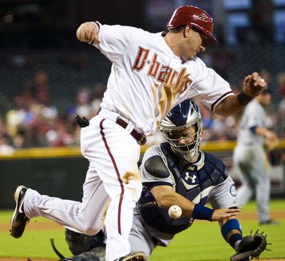 Arizona Diamondbacks' Willie Bloomquist knocks the ball away from Seattle Mariners catcher Jesus Montero while scoring during the first inning of an interleague baseball game, Monday, June 18, 2012, in Phoenix. (Michael Chow / The Arizona Republic)