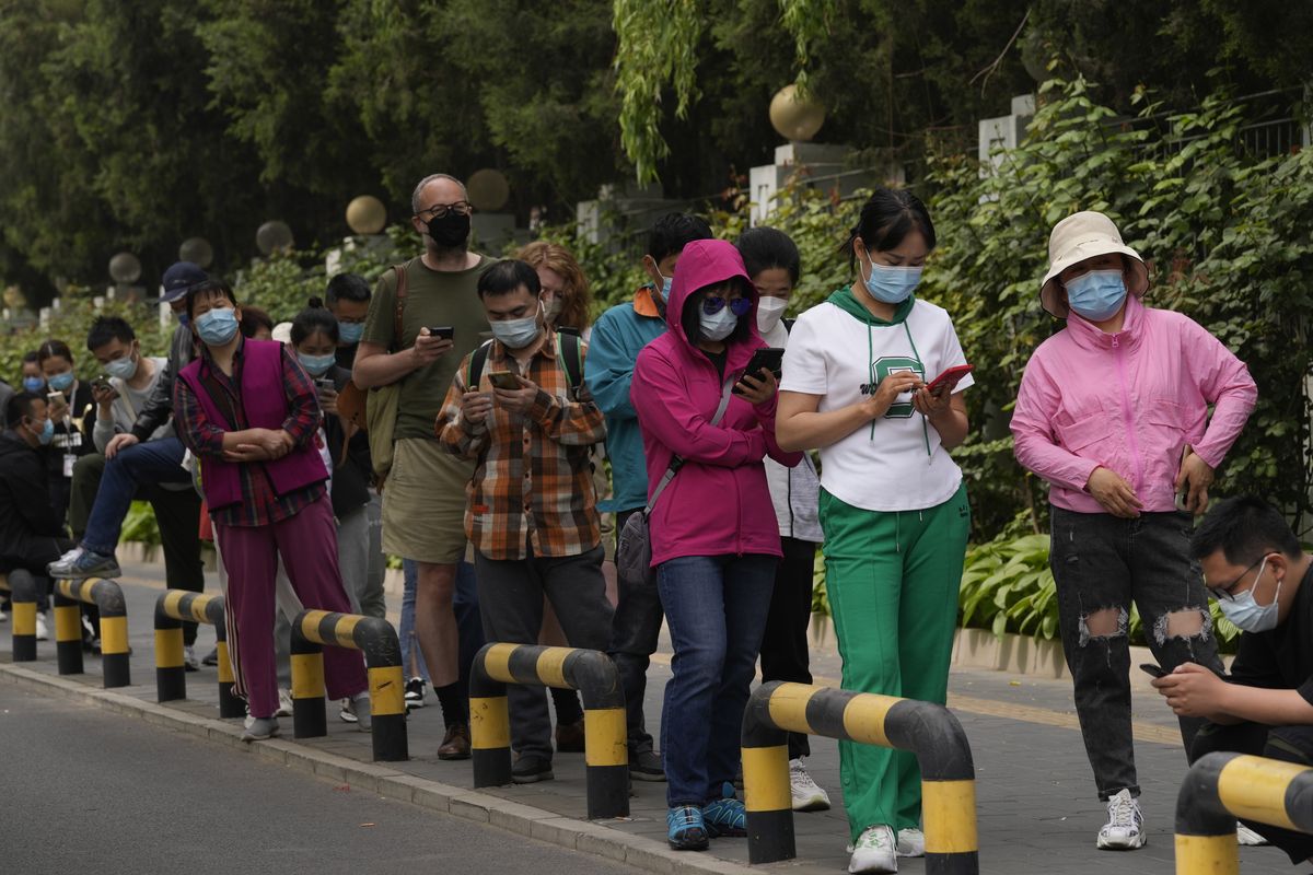 Residents wearing masks line up for mass COVID testing in Chaoyang District on Monday, April 25, 2022, in Beijing.  (Ng Han Guan)