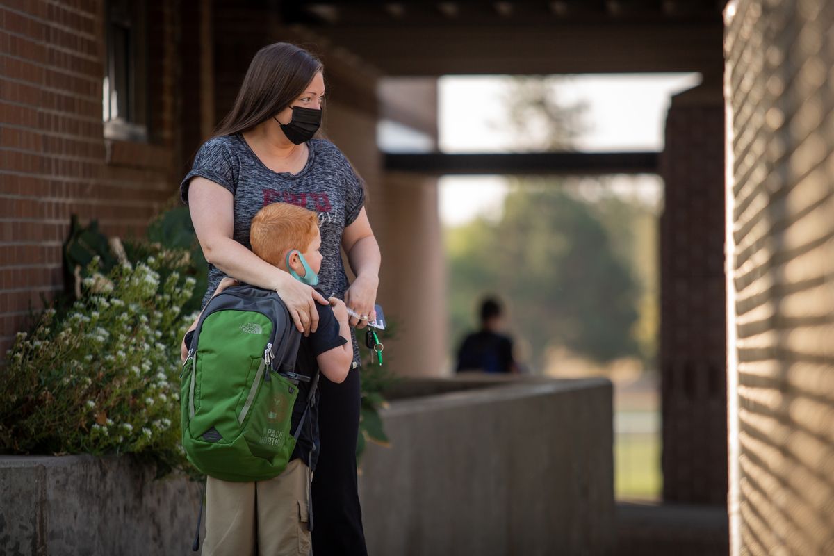 First grader Quintin Reisenauer clings to his mom, Kaitlin Reisenauer, on the first day of the 2021-2022 school year at Salnave Elementary School on Wednesday, Sept. 1. Students are masked and in-person for classroom learning in the Cheney Public School District.  (Libby Kamrowski/ THE SPOKESMAN-REVIEW)