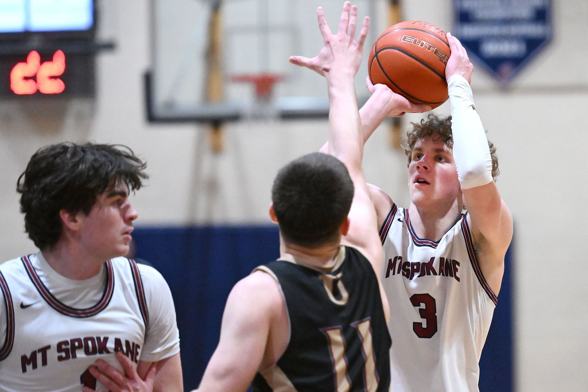 Mt. Spokane guard Ryan Lafferty goes up for a 3-pointer against University guard AJ Wolfe during a District 8 3A boys semifinal at Mt. Spokane High School on Tuesday.  (James Snook)