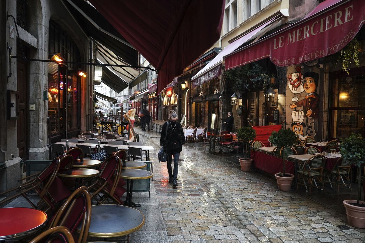 A woman walks by empty restaurants on Oct. 2 in the center of Lyon, central France.  (Laurent Cipriani)