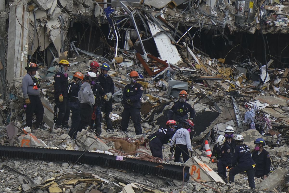 Search and rescue personnel work atop the rubble at the Champlain Towers South condo building, where scores of people remain missing almost a week after it partially collapsed, Wednesday, June 30, 2021, in Surfside, Fla. (Lynne Sladky)