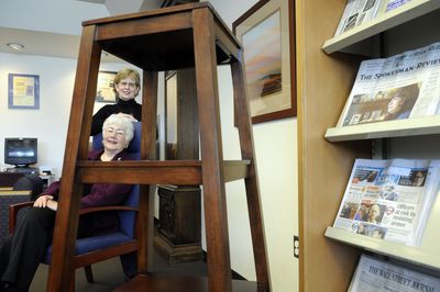 Debi Roccanova, top, and Jan Matthews  helped decorate the adult reading room with a book tower, artwork and recovered chairs.  (Dan Pelle / The Spokesman-Review)