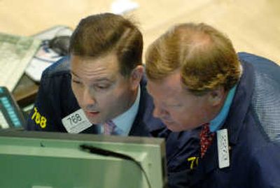 Richard Zboray, right, and George Eckstein, both of Van der Moolen Specialists, look at a monitor from the floor of the New York Stock Exchange, on Friday. Associated Press
(Associated Press / The Spokesman-Review)
