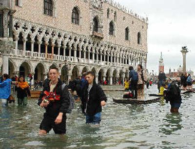 
Tourists and residents make their way through a flooded St. Mark's Square in Venice, northern Italy. 
 (Associated Press / The Spokesman-Review)