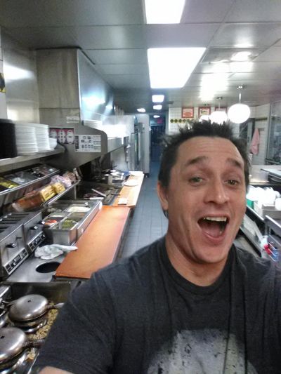 In this image taken early Thursday, Nov. 30, 2017, Alex Bowen poses in the kitchen at a Waffle House in West Columbia, S.C. When Bowen found the only worker at the empty South Carolina Waffle House asleep, he took his meal into his own hands. Bowen chronicled with selfies how he made his own double Texas bacon cheese steak melt on Facebook. (Alex Bowen / Associated Press)