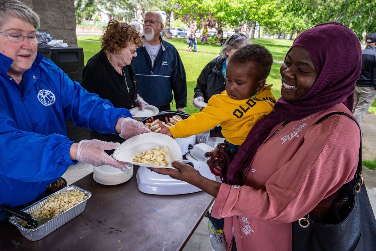 During Neighbor’s Day, volunteer Kea Woodfill hands Zahra Hamza and her son Morad, age one and a half, some pasta salad at the picnic shelter in A.M. Cannon Park, Friday, June 3, 2022. West and East Central community organizations partnered to celebrate 30-years of community events together with a gathering featuring music, food, and informational booths in the park.  (COLIN MULVANY/THE SPOKESMAN-REVIEW)