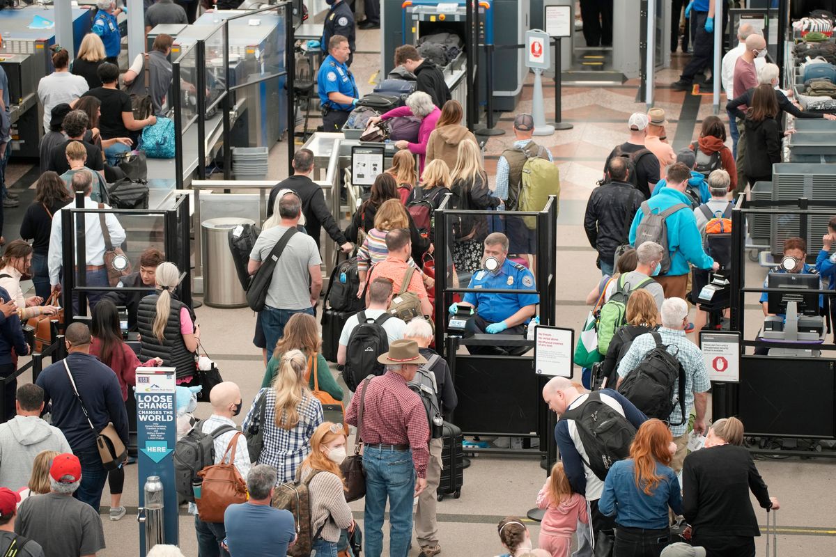 FILE - Travelers queue up move through the north security checkpoint in the main terminal of Denver International Airport, Thursday, May 26, 2022, in Denver. Airline travelers are not only facing sticker shock this Memorial Day weekend, the kick off to the summer travel season, but they