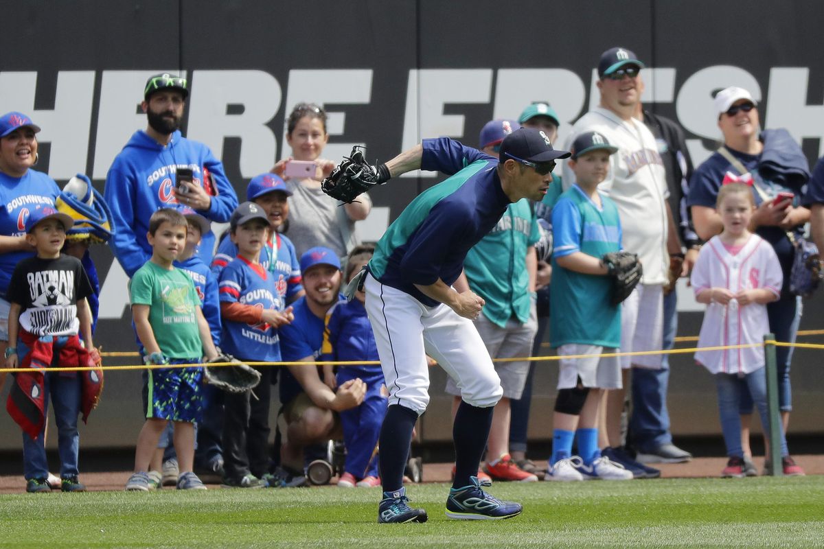 The Mariners’ Ichiro Suzuki, who moved from being a player to a front-office role, catches baseballs behind his back in front of fans taking part in a field walk before a game Sunday, May 6, 2018, against the Los Angeles Angels at Safeco Field. (Ted S. Warren / Associated Press)