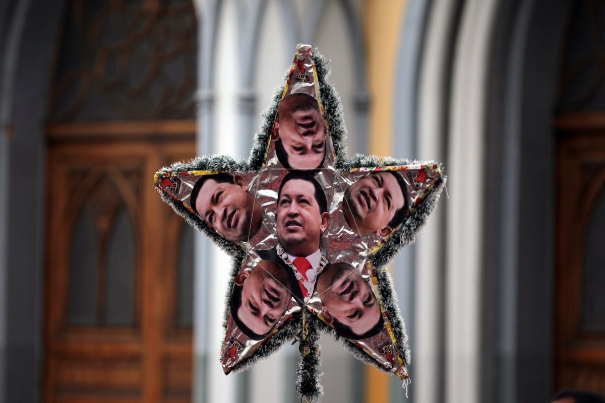 A supporter of President Hugo Chavez holds up a star covered in photographs of Chavez outside the National Assembly in Caracas, Venezuela, Saturday. (Associated Press)