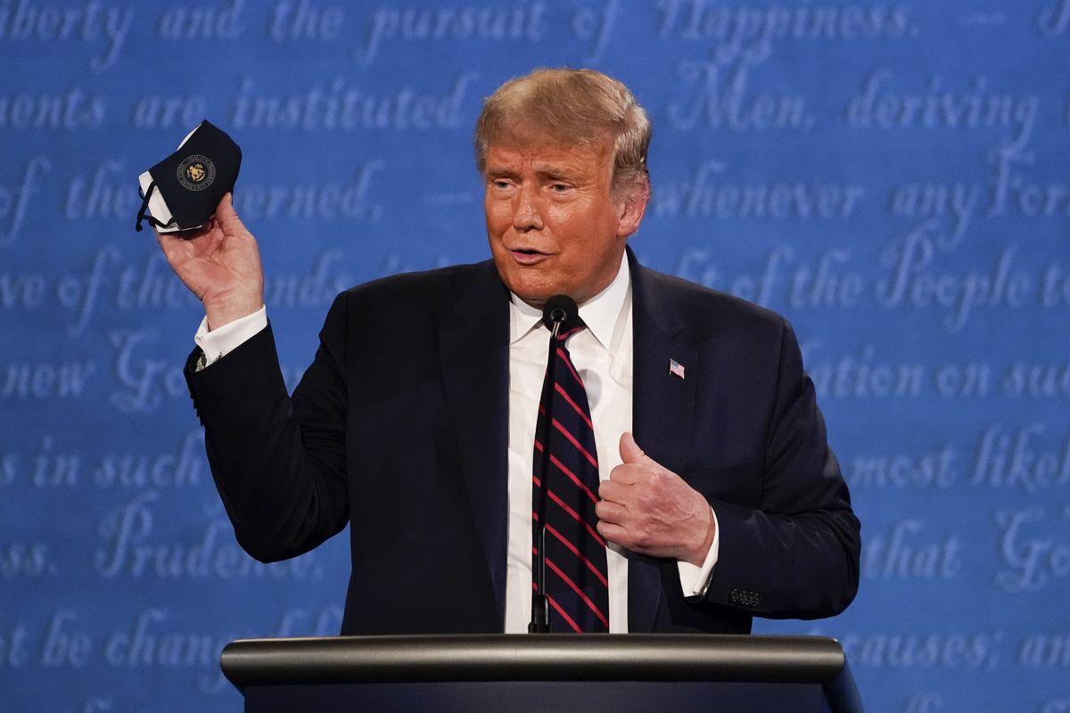 President Donald Trump holds up his face mask during the first presidential debate Sept. 29, 2020, at Case Western University and Cleveland Clinic, in Cleveland, Ohio. President Trump and first lady Melania Trump have tested positive for the coronavirus, the president tweeted early Friday.  (Associated Press)