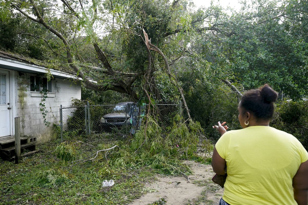 Seleka Souls looks over a neighbor’s home that was damaged Friday by Hurricane Sally in Pensacola, Fla.  (Gerald Herbert)