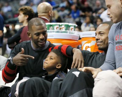Los Angles Clippers guard Chris Paul, left, talks with his son Chris Jr., as Paul Pierce and Blake Griffin, right, sit by on the bench late in the second half of an NBA basketball game against the Dallas Mavericks on Wednesday, Nov. 23, 2016, in Dallas. (Tony Gutierrez / Associated Press)
