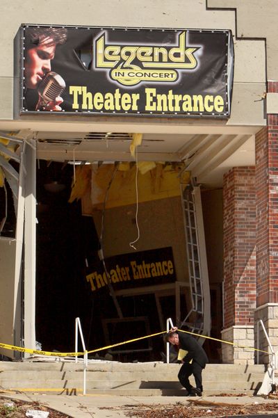 An employee ducks under caution tape at the Dick Clark’s American Bandstand Theater in Branson, Mo., on Feb. 29. (Associated Press)
