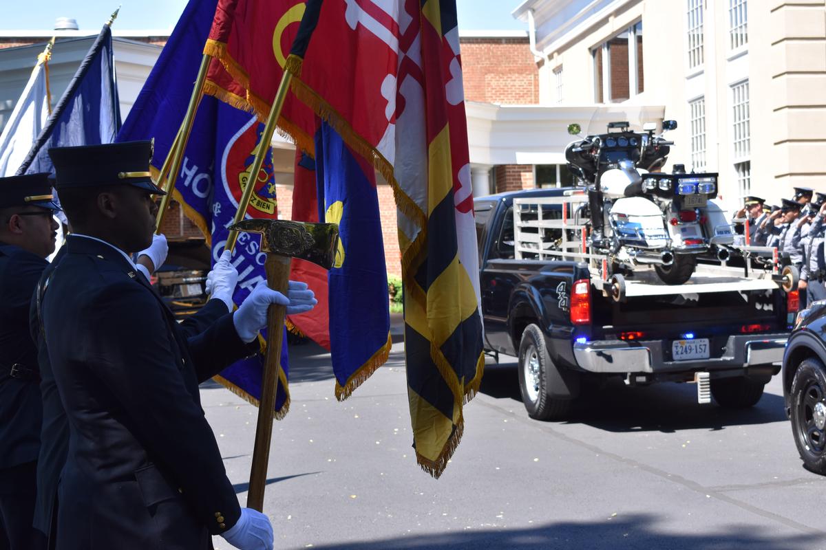 Honor Guard members raise their flags, after the motorcycle honoring Arlington County Police Cpl. Barry Foust arrives at Cherrydale Baptist Church in Arlington, Virginia.   (Juan Benn Jr./TWP)