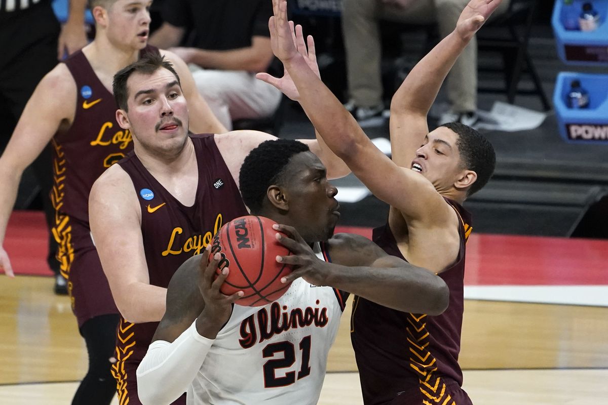 Illinois center Kofi Cockburn is defended by Loyola Chicago center Cameron Krutwig, left, and Lucas Williamson, right, during the second round of the NCAA Tournament at Bankers Life Fieldhouse in Indianapolis on Sunday.  (Associated Press)