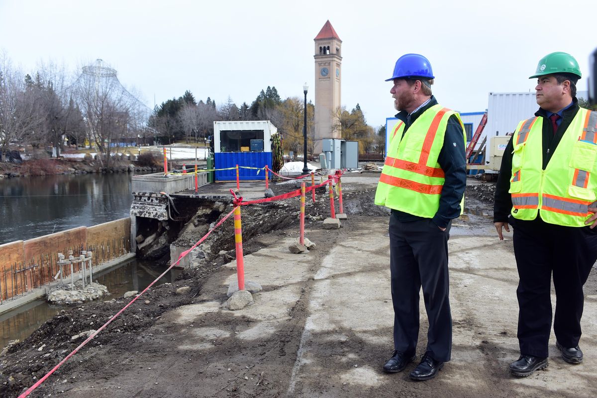 Parks and Recreation Director Leroy Eadie, left, and program manager Berry Ellison, right, examine the progress of removing the Howard Street Bridge  in Riverfront Park on Thursday. (Jesse Tinsley / The Spokesman-Review)