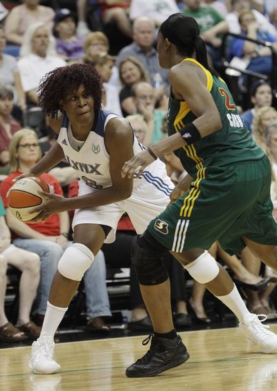 Minnesota Lynx forward Taj McWilliams-Franklin, left, looks to pass against Seattle Storm forward Swin Cash on Saturday. (Associated Press)
