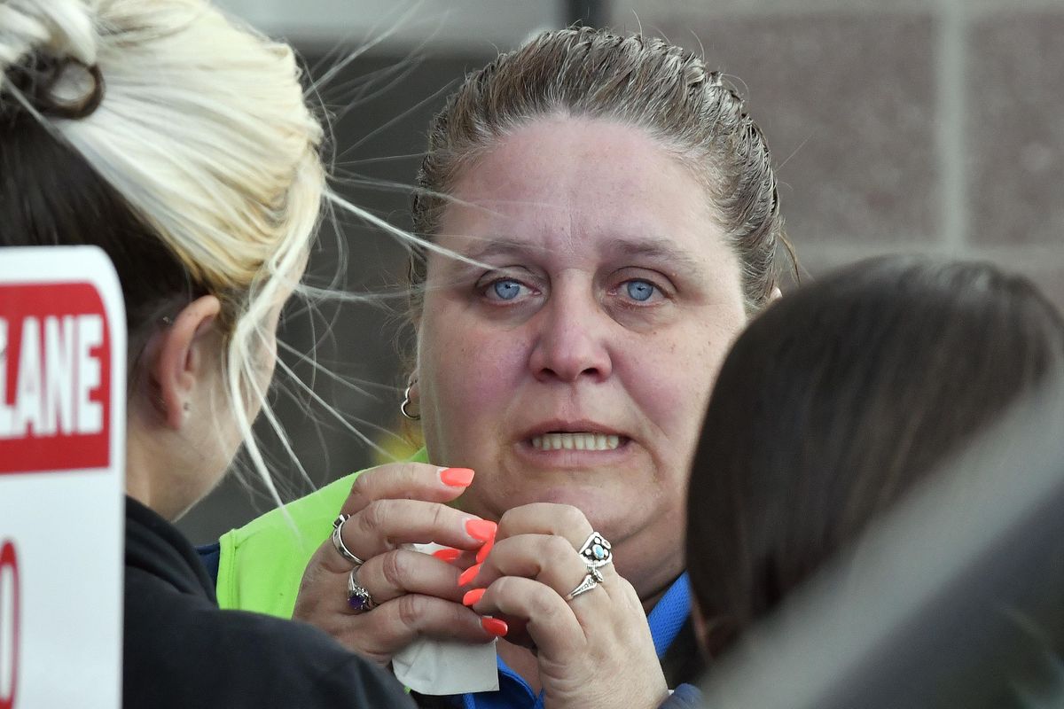 A Kroger employee wipes away tears following a shooting that left two people dead, and the subject in custody, Wednesday, Oct. 24, 2018, in Jeffersontown, Ky. (Timothy D. Easley / Associated Press)
