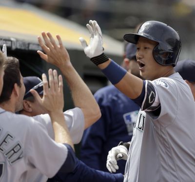 Seattle’s Dae-Ho Lee, right, is congratulated after hitting a two-run home run off Oakland’s John Axford in the seventh inning Wednesday. (Ben Margot / Associated Press)