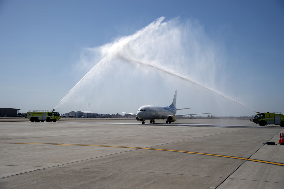 A jet carrying the Gonzaga men’s basketball team is greeted by a water arch formed by two Spokane International Airport fire trucks after landing at the airport Tuesday  (Jesse Tinsley/The Spokesman-Review)