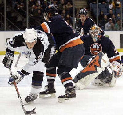 Tampa Bay's Vincent Lecavalier, left, finds the puck in a crowd of Islanders. 
 (Associated Press / The Spokesman-Review)