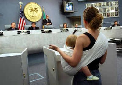 
Christina Costa, with her baby, Angelina, 1, speaks in support of Miami Beach, Fla., commission candidate Gabrielle Redfern at a Wednesday meeting. 
 (Associated Press / The Spokesman-Review)