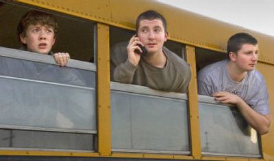 
Lewis and Clark High School students, from left, Chris Anderson, Andy Gerard and his brother, Steve Gerard, wait in a bus Wednesday after being evacuated from the school in Spokane because of a bomb threat. Students were bused to the Spokane Arena. 
 (Christopher Anderson / The Spokesman-Review)