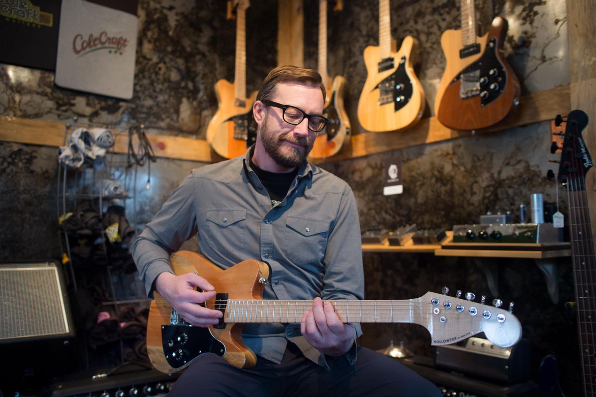 Eben Cole poses for a photo with one of his Cole Music Co. Hollowtop guitars at his shop on Wednesday, Jan. 25, 2017, in Spokane, Wash. (Tyler Tjomsland / The Spokesman-Review)