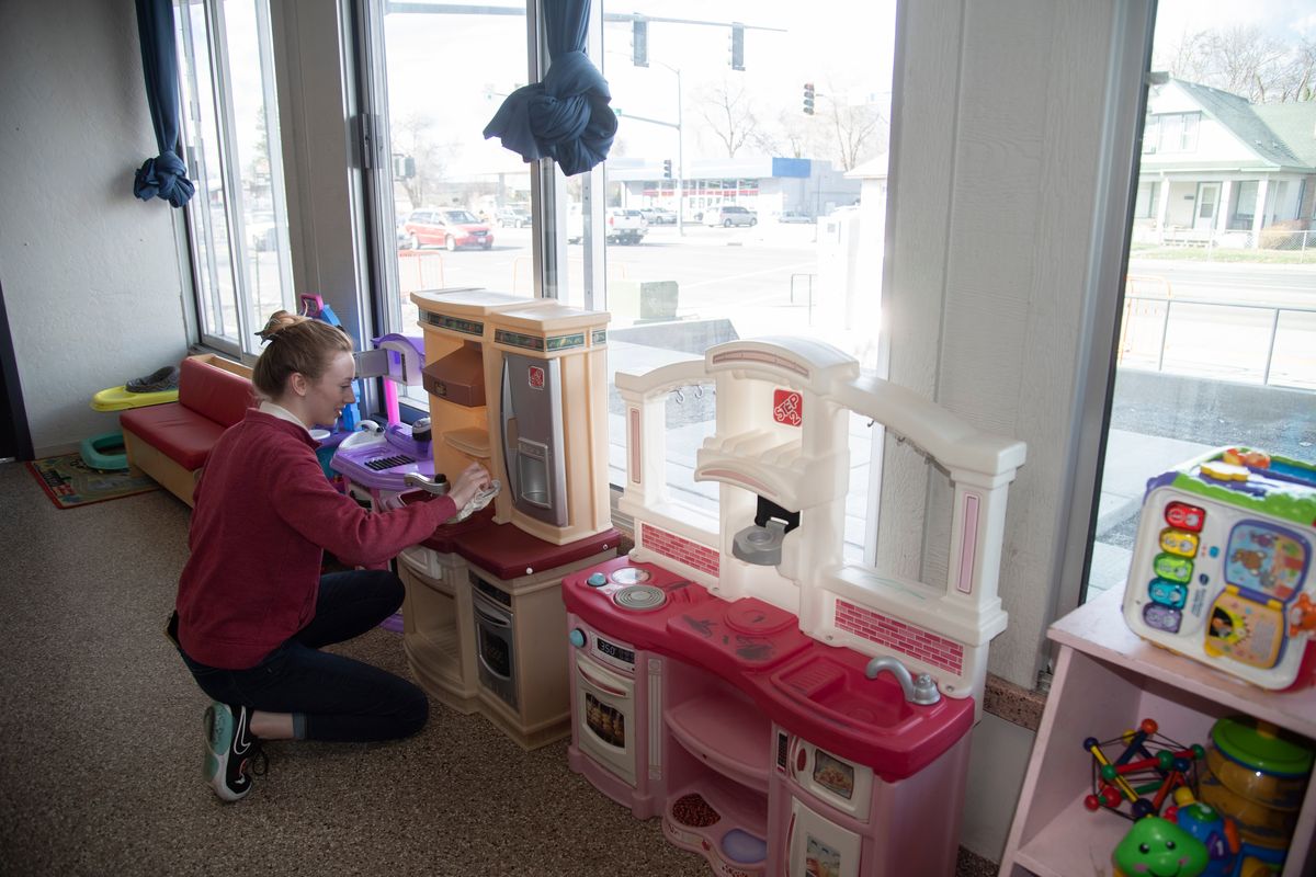 Whitworth University student and volunteer Trillium Bristow helps out by cleaning toys at the Family Promise shelter at 2002 E. Mission Ave. on Tuesday. The nonprofit, which is marking 25 years in Spokane County this month, houses homeless families as they try to get their own housing.  (Jesse Tinsley/The Spokesman-Review)